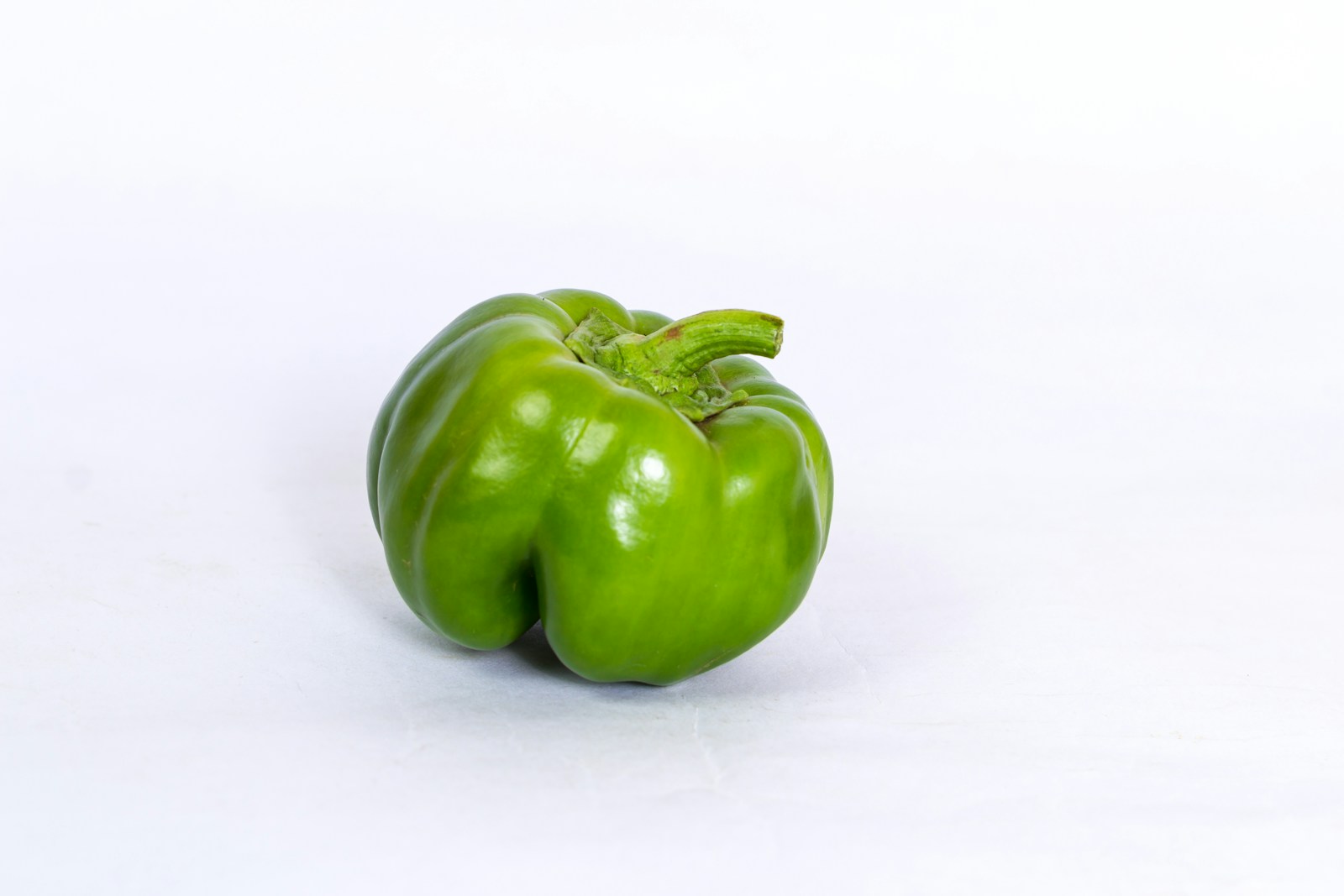 green bell pepper on white surface